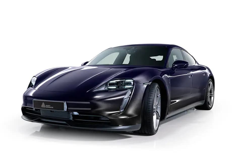 Studio photo of a Porsche Taycan finished in Mystery Black, an Avery Dennison plate on the front bumper