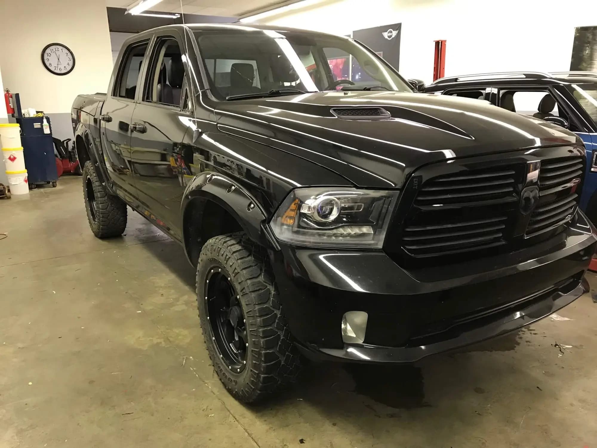 Dodge Ram crew cab pickup wrapped in Gloss Midnight Blue, the deep navy reading near-black under the shop lights