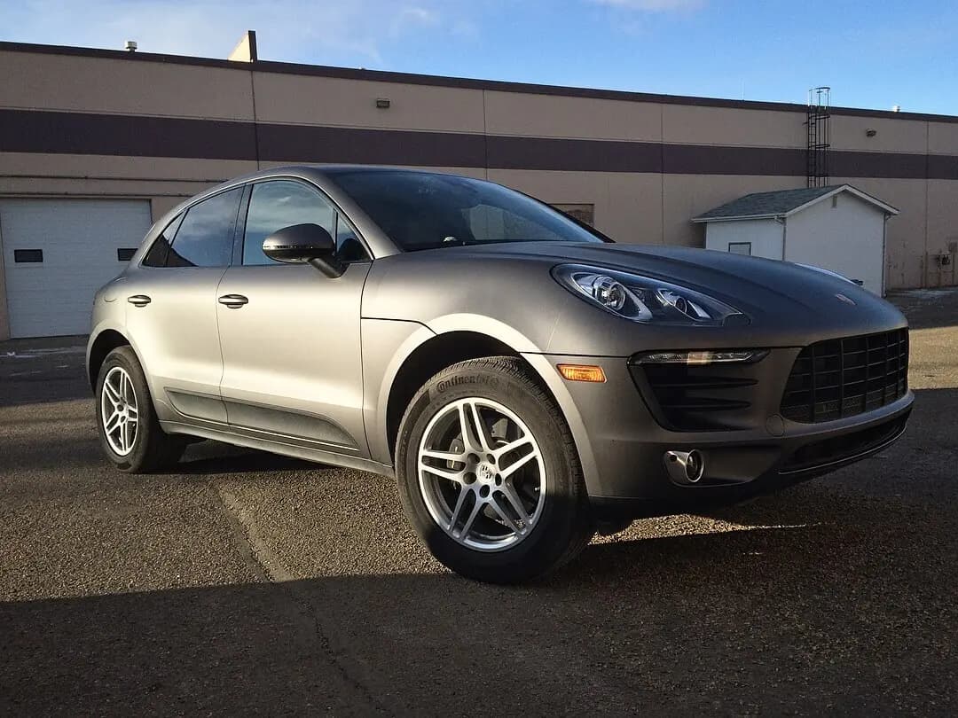 Porsche Macan wrapped in Matte Dark Gray, parked outside on a paved lot